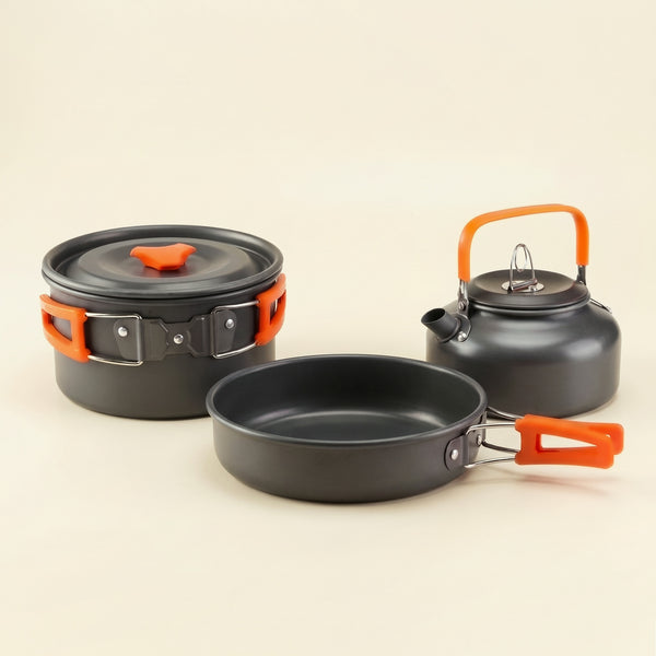 Camping cook set in dark gray aluminum with orange handles: pot with lid, frying pan and kettle