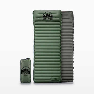 Green Restwild Mattress Pro V2 sleeping pad with horizontal air channels and a built-in pillow, shown with its gray underside and green stuff sack