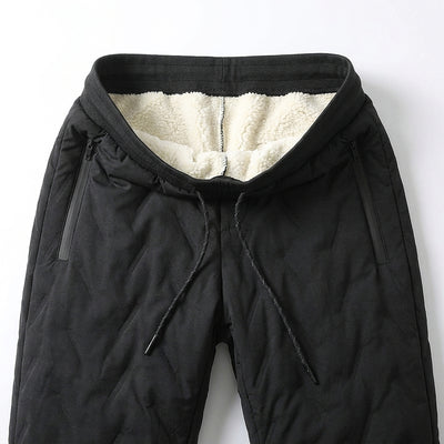 Waistband of the black winter pants folded open: cream sherpa fleece lining, drawcord and two zippered side pockets