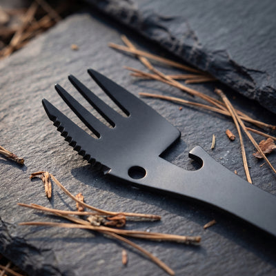 Close-up of the fork end of the camping spork with its serrated knife edge, round hole and hooked can opener notch