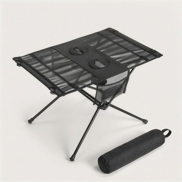 Black folding camping table with two cup holders and a mesh side pocket, next to its black carry bag